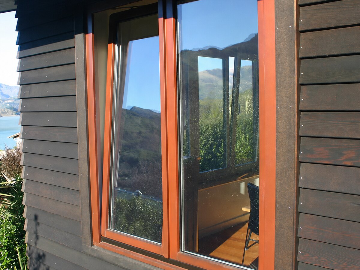 Timber-clad home with rust-coloured window frames