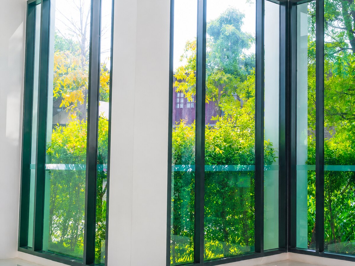 Floor-to-ceiling corner glazing looking out over trees