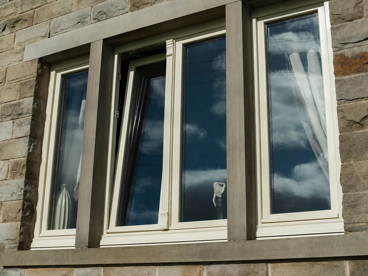 Cream-framed windows set in a stone facade